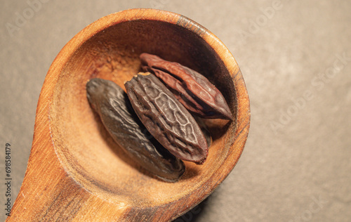 Tonka Beans in a wooden Spoon on a dark background photo