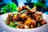 Gobi Manchurian Homemade, Indo Chinese fried Cauliflower florets, Gobi Manchurian is Indian Chinese cuisine dish with cauliflower, tomatoes, onion, soy sauce in white plate selective focus.