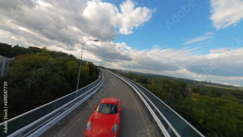 FPV shot of a Ferrari following behind a Lamborghini down a winding country road, Aerial red and yellow sports car, Enjoying scenic car ride on a sunny day, Sports car driving at a motor racing track