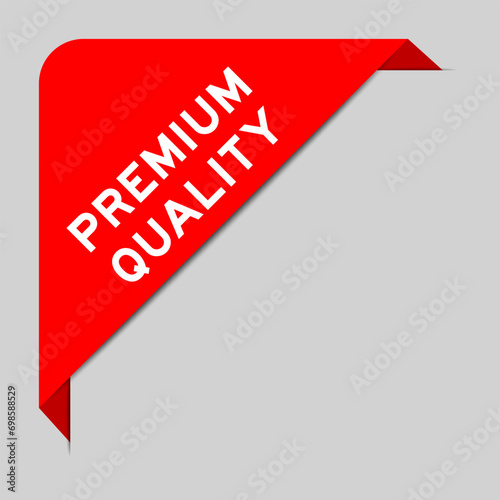 Red color of corner label banner with word premium quality on gray background