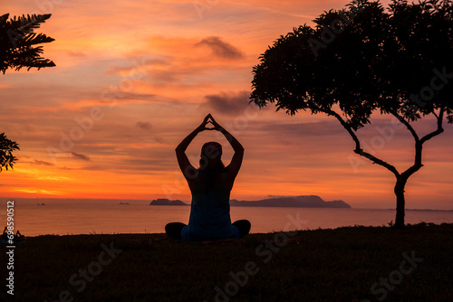 Fototapeta Naklejka Na Ścianę i Meble -  young woman practicing Yoga on a beutiful and calm sunset at Miraflores park Lima Peru

