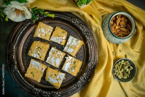 Festival Season Indian Sweets, Chickpeas and Coconut Barfi or Chickpeas and Coconut Barfee in Brass Plate, Top View. photo