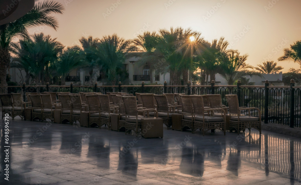 chairs on the terrace without people in a hotel at sunrise in Egypt