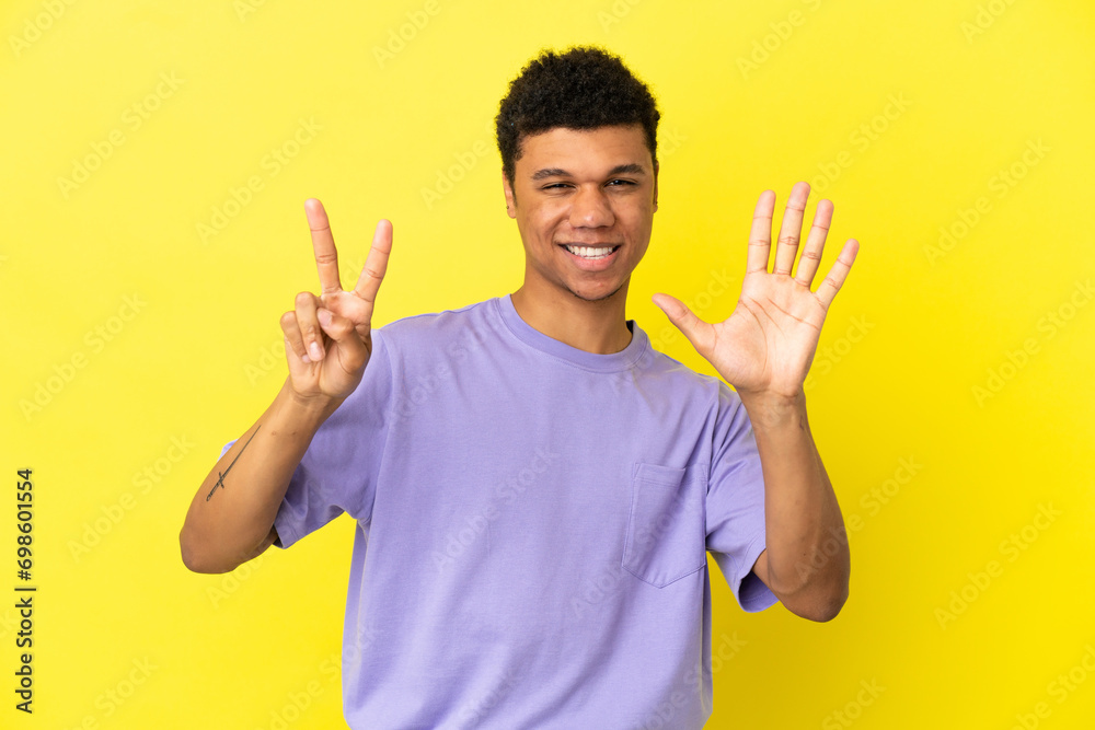 Young African American man isolated on yellow background counting seven with fingers Young African American man isolated on yellow background counting seven with fingers