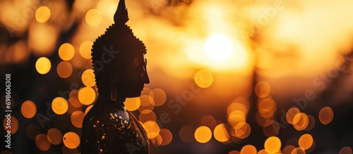 Buddha silhouette with sun behind, blurred bokeh. photo