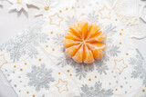 rozetka z owocu mandarynki na świątecznym obrusie bożonarodzeniowym