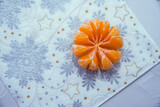 rozetka z owocu mandarynki na świątecznym obrusie bożonarodzeniowym