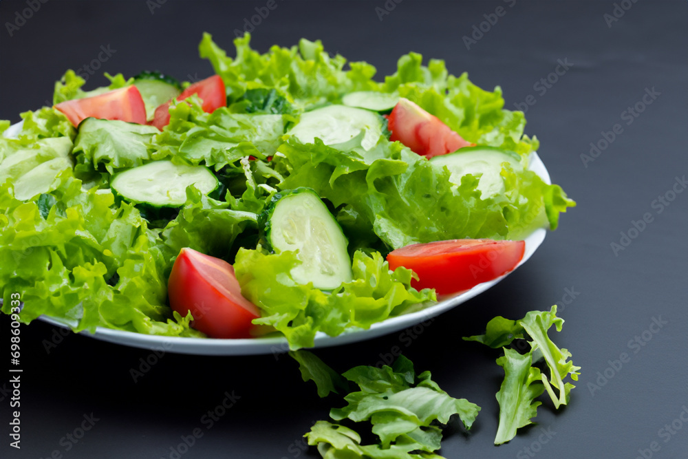 vegetarian salad. salad with herbs, tomatoes and cucumbers on a black plate. healthy food concept vegetarian salad. salad with herbs, tomatoes and cucumbers on a black plate. healthy food concept