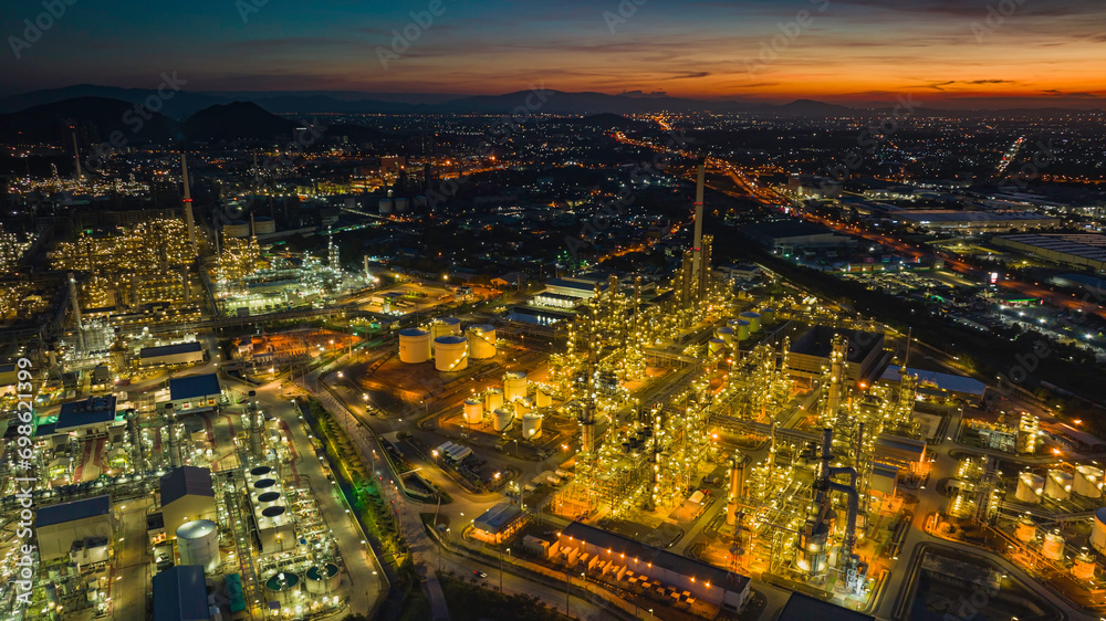 Fototapeta premium Aerial view of the morning of the oil refinery from the drone of the tower of the Petrochemistry industry in the oil and gas industry with cloud sun orange