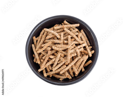All bran cereal in black bowl isolated on white background, top view