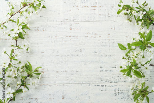 Blooming white apple or cherry blossom on white wooden background. Happy Passover background. Spring Easter background. World environment day. Easter, Birthday, womens day holiday. Top view. Mock up.