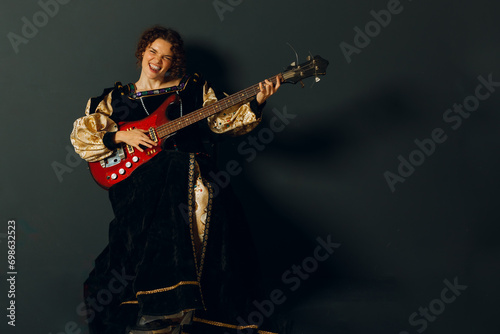 Portrait of a young adult woman playing rock music on electric guitar and dressed in a medieval dress