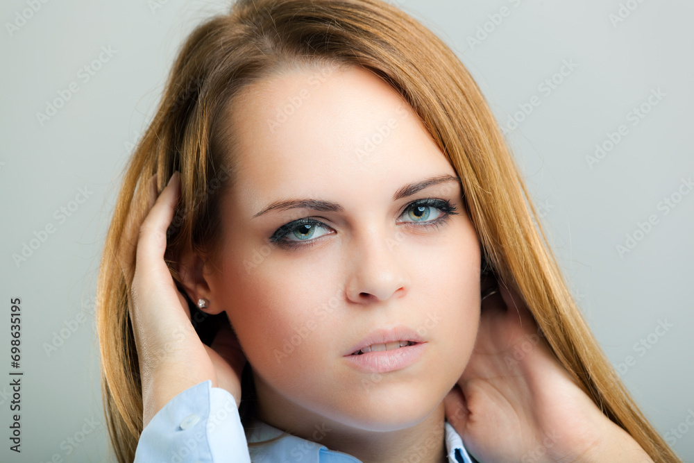 Obraz premium Confident young woman posing with hand in hair