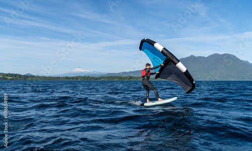 Young person learning to wingfoil on the lake with the volcano in the background. © Emilia