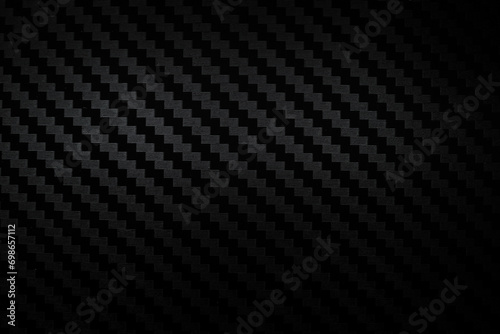 Carbon fiber composite raw material background. Carbon fiber texture. Dark Gray background with lighting.