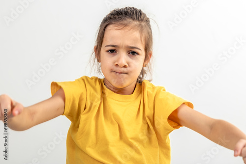 Little Caucasian girl driving invisible car isolated on white background.