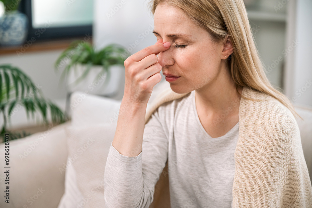 woman with headache touching her nose bridge and feeling tired woman with headache touching her nose bridge and feeling tired