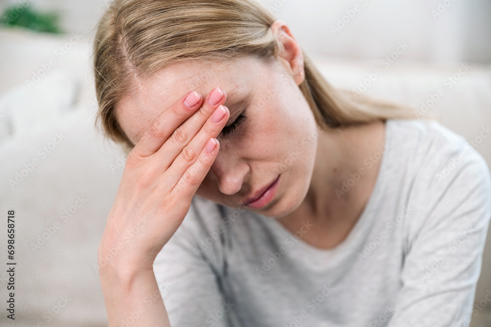 Fototapeta premium upset woman touching her forehead and thinking about problems