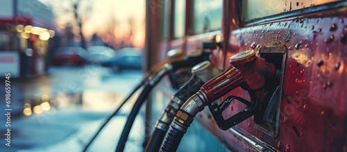 Gas station hoses, featuring gasoline and diesel fuel, against the window backdrop. photo