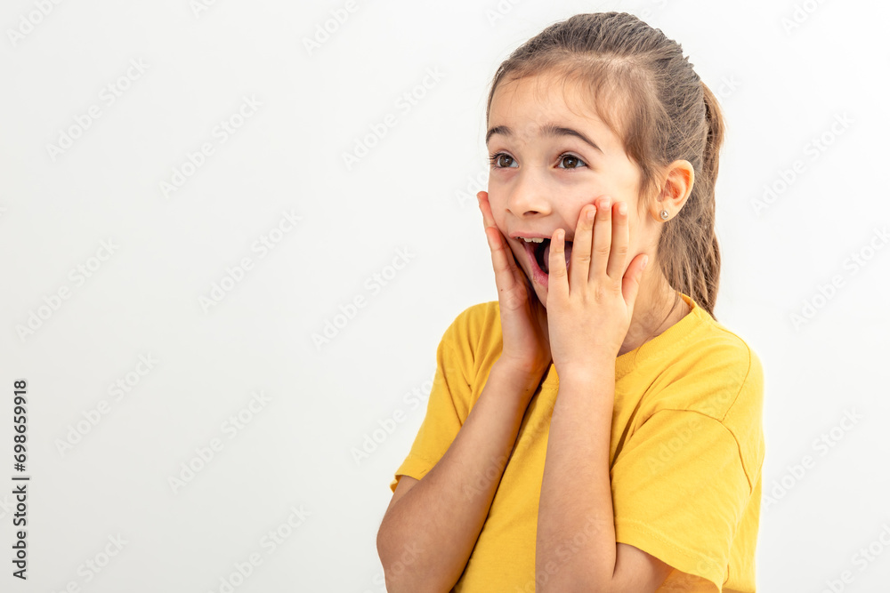 Little Caucasian girl makes funny faces on a white background isolated. Little Caucasian girl makes funny faces on a white background isolated.
