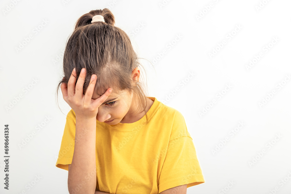 A little girl holds her palm on her face on a white background isolated. A little girl holds her palm on her face on a white background isolated.