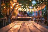 A romantic outdoor dining setting with a wooden table under a canopy of twinkling lights and a blurred couple in the background