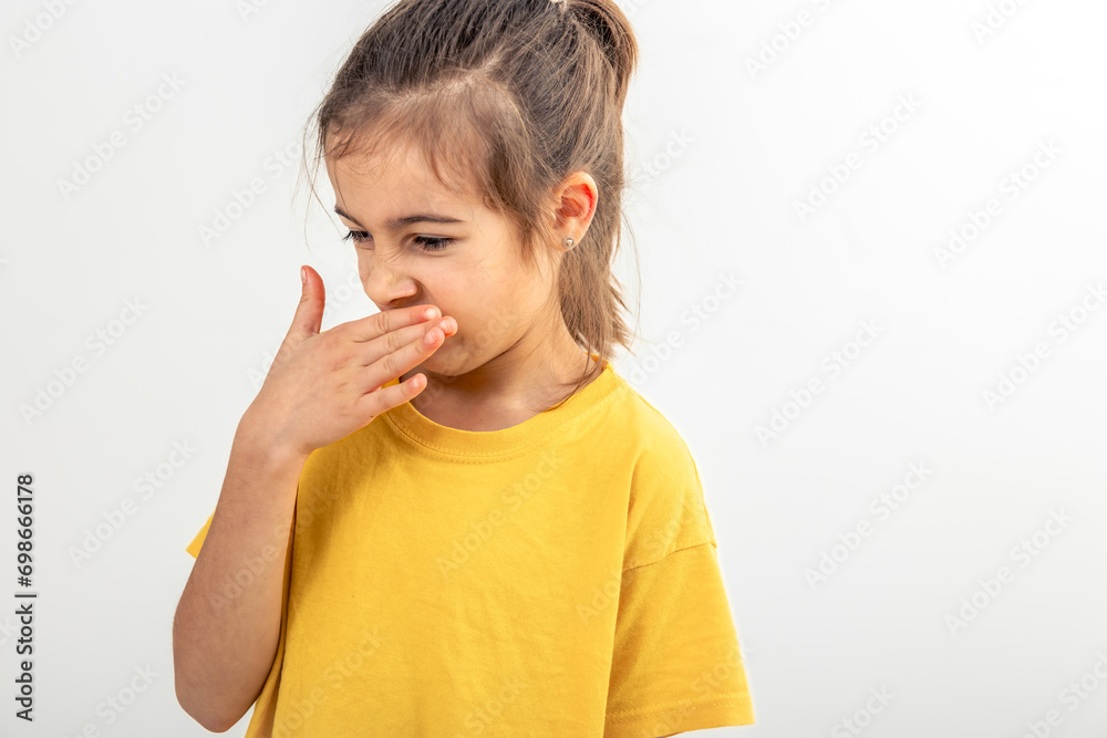 Little school girl feeling bad and dislike smell, isolated on white background. Little school girl feeling bad and dislike smell, isolated on white background.