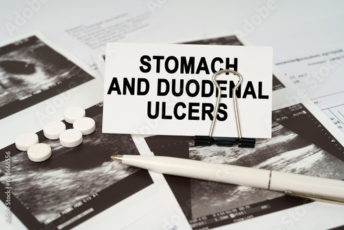 On the ultrasound pictures there is a pen and a business card with the inscription - Stomach and duodenal ulcers photo