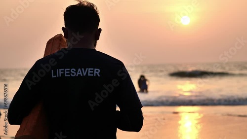 beach lifeguard keeps order in the ocean photo