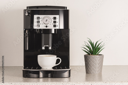Tablou pe pânză Modern espresso coffee machine with a cup in kitchen.