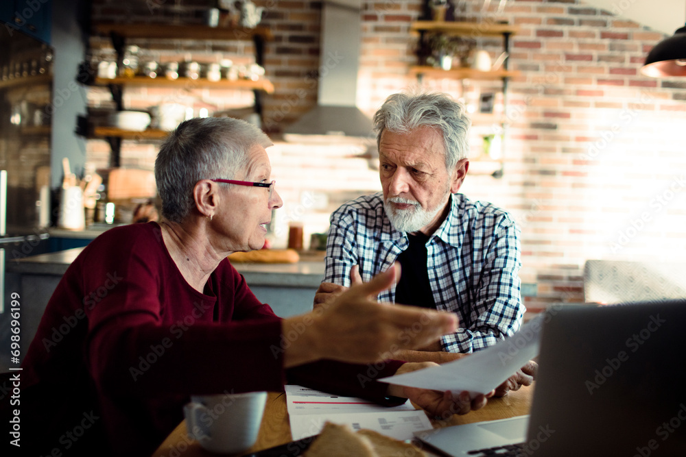 Senior partners discussing bills at home