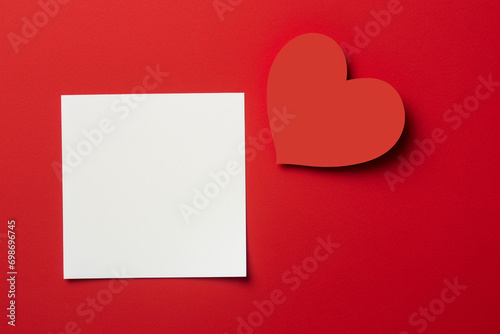red heart paper and blank with note card on red background