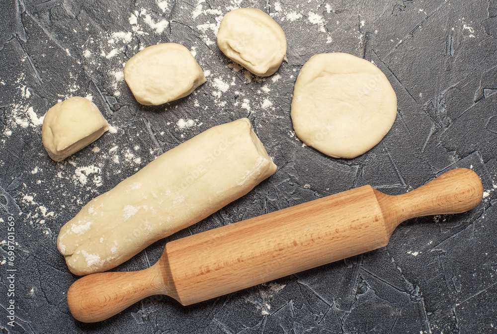 ball of fresh raw dough, flour and rolling pin top view