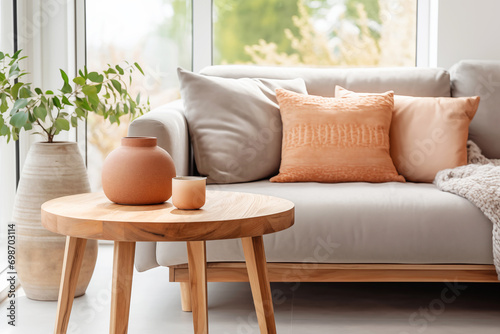 Minimal living room with wooden coffee table near sofa close-up. Interior in trendy peach colors photo