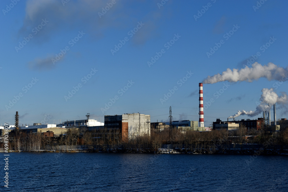 The smoking pipe of a thermal power plant and a reservoir. The urban landscape in Yekaterinburg.