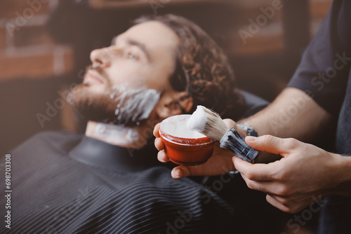 Brush for shaving beard along, blurred background of hair salon for men, barber shop. photo