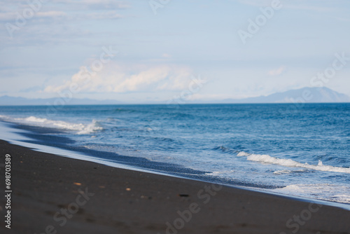 Landscape of Khalaktyrsky beach with black volcanic sand coast of North Pacific Ocean Kamchatka Russia photo