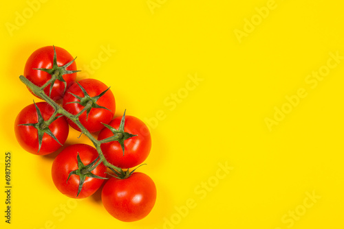 Red cherry tomatoes on a yellow background