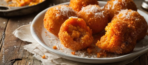 Sicilian street food: Arancino with ragu on white plate.