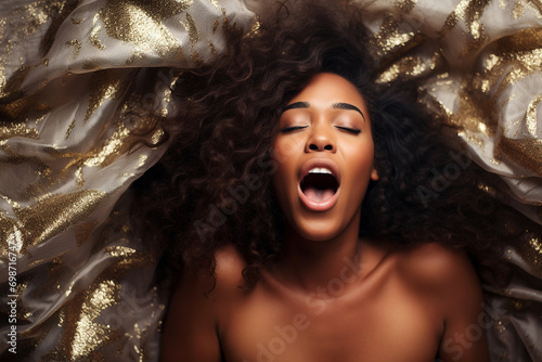 African american woman having orgasm. Woman with open mouth and closed eyes enjoying sex lying among flying glitter and sparkles as a symbol of orgasm. Sexual experience, masturbation, cunnilingus. photo