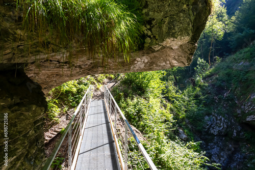 Scenic hiking path through the gorge of Tscheppaschlucht, Loibl Valley, Karawanks, Carinthia, Austria. Narrow canyon, unique rock formation in forest. Constructed walkway along cliffs and rocks