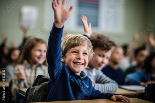 Young boy raising hand in elementary school classroom photo