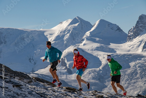 Mountain running trio in colorful attire photo