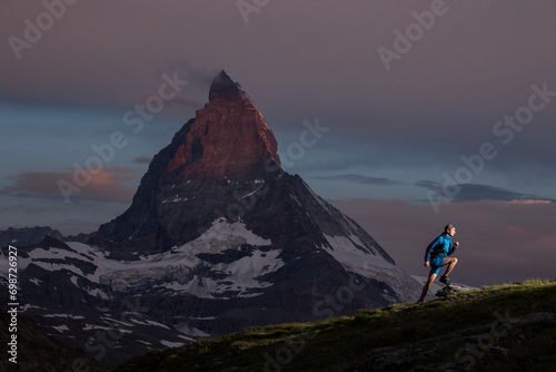 Alpine trail running at dusk with mountain backdrop photo