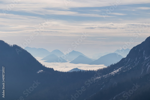 Panoramic view of beautiful Karawanks mountain range in Carinthia, Austria. Magical atmosphere in remote alpine landscape in Slovenian Austrian Alps. Misty fog in valley. Tranquil scene in wilderness