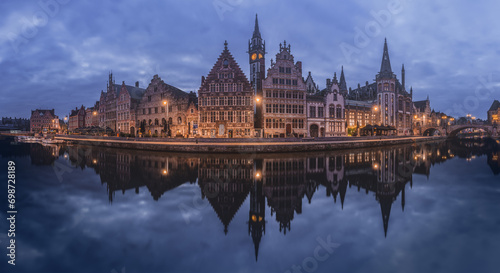 The historic buildings of Ghent are mirrored in the calm waters during twilight, showcasing the city's medieval charm photo