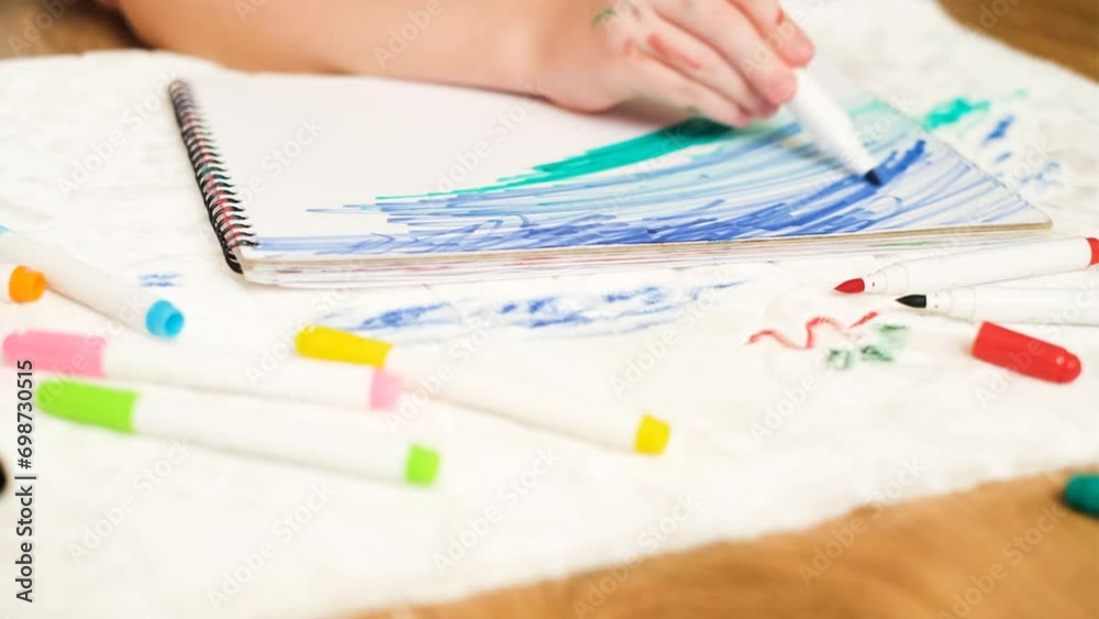 Unrecognizable child drawing with a green felt-tip pen on a sheet of paper. Dirty stain felt-tip pens on the white upholstered furniture or a carpet. High quality 4k footage Unrecognizable child drawing with a green felt-tip pen on a sheet of paper. Dirty stain felt-tip pens on the white upholstered furniture or a carpet. High quality 4k footage