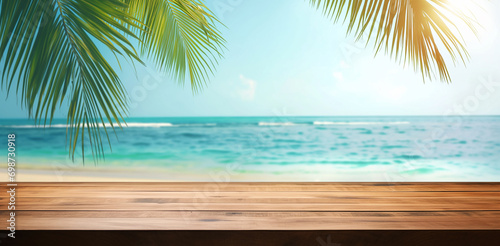 Summer tropical sea with waves  palm leaves and blue sky with clouds. Perfect vacation landscape with empty wooden table.