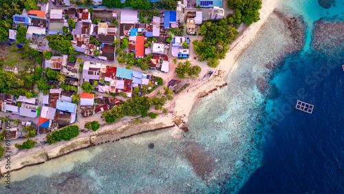 Closeup Drone Aerial View Looking Down on Island Beach Town Homes in the Maldives with Dynamic Blue Water Views