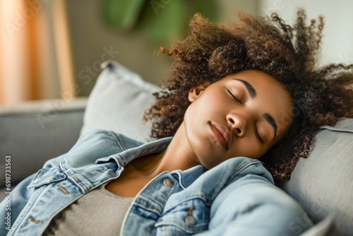 Relaxed tired young african american woman napping on comfortable sofa with eyes shut closed. Calm lazy black girl leaning on couch in living room enjoying chill sleeping resting at home concept photo